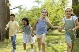 gruppe asiatischer und kaukasischer kinder, die spaß im park haben foto