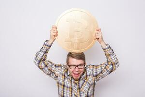 verrückt Bitcoin Liebhaber mit groß golden Münze, komisch Bergmann mit Münzen. foto