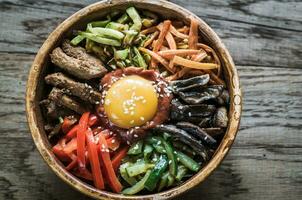 Schüssel von bibimbap auf das hölzern Tabelle foto