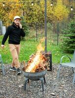 ein Mann Beleuchtung ein Grill im Natur foto