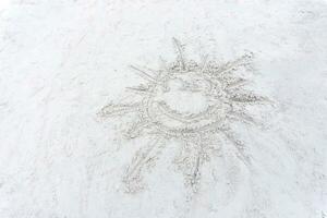 Lächeln Sonne Zeichnung auf ein Weiß Sand Strand foto