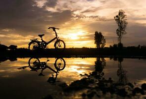 Silhouette falten Fahrrad Park auf das am Wasser. foto