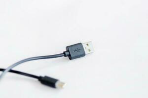 Nahansicht von schwarz USB Laden Kabel, kompatibel zum viele Geräte, isoliert auf Weiß Hintergrund. foto