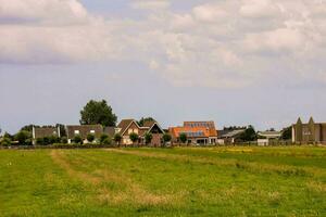 ein Feld mit Häuser und ein Kirche im das Hintergrund foto