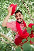 ein froh und heiter Mime mit ein Lächeln sitzt auf ein Baum. das Clown lächelt freundlich. foto