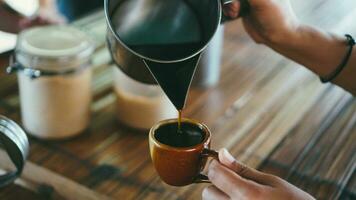 Barista ist Gießen heiß Wasser von klassisch Krug zu Arabica Kaffee im Filter. Konzept zum Hipster Lebensstil Wer mögen schleppend Leben und tauchen Kaffee. foto