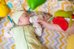 Mutter Einspeisungen ein Neugeborene Baby mit Milch von ein Flasche foto