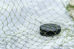 Eishockey Puck im das Tor Netz Nahansicht foto