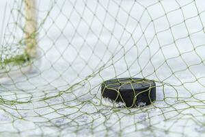 Eishockey Puck im das Tor Netz Nahansicht foto