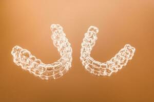unsichtbar Dental Zähne Klammern Zahn Aligner auf Orange Hintergrund. Plastik Hosenträger Zahnheilkunde Halter zu begradigen Zähne. foto