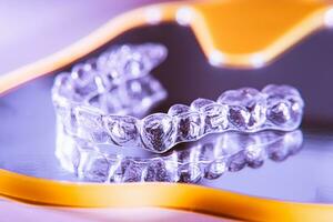 unsichtbar Dental Zähne Klammern Zahn Aligner auf lila Hintergrund. Plastik Hosenträger Zahnheilkunde Halter zu begradigen Zähne. foto
