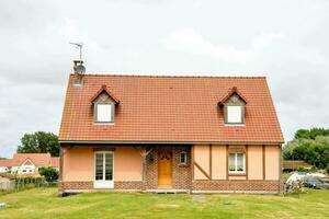 ein Haus mit ein rot Dach und ein Grün Rasen foto