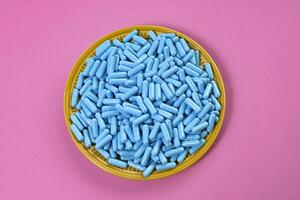Gelb Teller voll von Blau Medizin Kapseln Darstellen Droge Überdosis foto