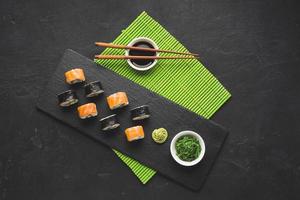 Sushi auf schwarzem Teller und grüner Bambusmatte