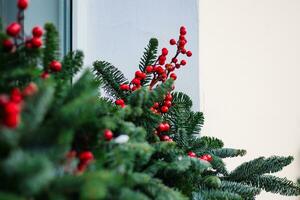 Weihnachten Dekorationen auf Fenster. Tanne Geäst mit rot Beeren. foto