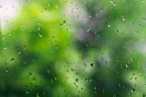 Aussicht von Glas mit Wasser Tropfen auf Fenster Schlafzimmer, Nahaufnahme. Regen Tropfen gleiten auf Fenster Glas foto