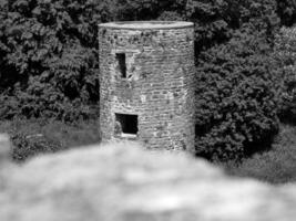 alt keltisch Schloss Turm unter das Bäume mit verschwommen Stein im das Vorderseite, Geschwätz Schloss im Irland, alt uralt keltisch Festung foto