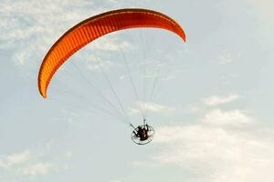 ein Person ist Gleitschirmfliegen im das Himmel foto