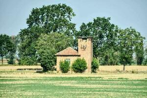 ein alt Backstein Gebäude im das Mitte von ein Feld foto