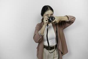 glücklich lächelnd jung asiatisch Frau Tourist Stehen mit Kamera nehmen Foto isoliert auf Weiß Studio Hintergrund