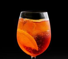 Glas von Aperol Spritz Cocktail auf schwarz Hintergrund foto