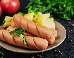 gekocht Würste mit Kartoffeln auf Teller foto