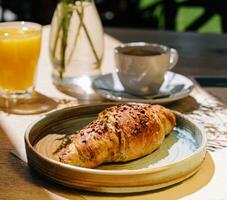 Tasse von frisch heiß Kaffee, Orange Saft und traditionell Französisch Croissant auf Tabelle von Pariser draussen Cafe im Paris foto