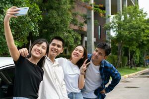 Gruppe von glücklich jung asiatisch Studenten Selfies und Videos mit Smartphones zusammen zum vlog und Sozial Medien auf Sommer- Urlaub. Konzept von Tourismus und Reise und Straße Reise, Freundschaft Lebensstil. foto