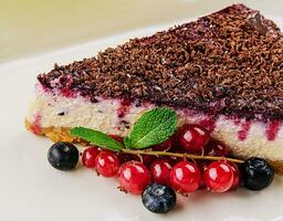 Vanille Käsekuchen mit Schokolade Soße und Beeren foto