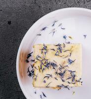 Französisch Mille feuille Kuchen mit Vanille Sahne dekoriert mit Blau Blume Blätter foto