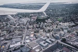 Luftaufnahme des Flugzeugflügels auf den Verkehr in der überfüllten Stadt foto