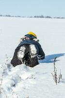 Junge gekleidet herzlich kriechen auf das Schnee foto