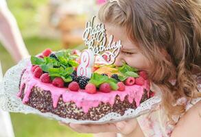 Mädchen nehmen beißen von aus Stück von Glückwunsch Kuchen. Geburtstag und Herzliche Glückwünsche Konzept. foto