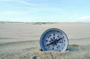 ein Kompass ist Sitzung im das Sand auf ein Strand foto