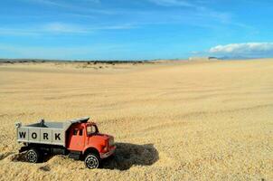 ein Spielzeug LKW ist Sitzung im das Sand foto