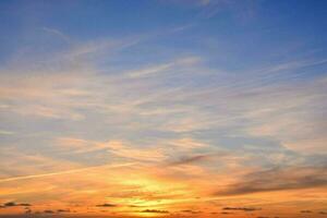 das Sonne setzt Über das Ozean und das Himmel ist Blau und Orange foto