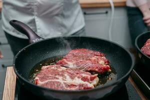 Kochen Rindfleisch Rippenstück Steak im ein braten schwenken im das Kochen Klasse. Steak mit Gewürze. Kochen Verfahren, Nahansicht. foto