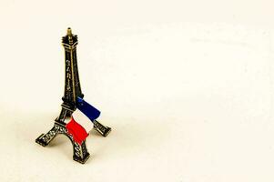 ein Miniatur Eiffel Turm mit ein Französisch Flagge auf oben foto