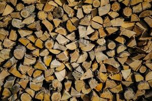 gestapelt Protokolle. geerntet Teilt Brennholz im ein Holzschuppen gestapelt im ordentlich Haufen. Vorbereitung von Brennholz zum Blackout. Energie Katastrophe im Ukraine foto