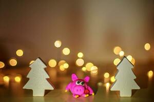 Symbol von Jahr 2019 Schwein von Plastilin. Weihnachten Hintergrund. Schwein beim das Weihnachten Fichte. Bokeh zum Neu Jahr Gruß Karte. foto