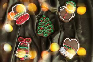 Banner zum Weihnachten und Neu Jahr Lebkuchen. Weihnachten Bäume, Spielzeuge, Schneemänner, Girlanden auf ein Hintergrund von braun Seide Stoff. hell Bokeh. foto