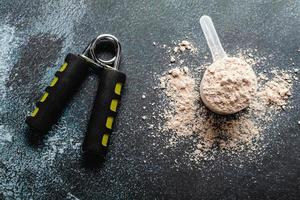 Messlöffel gefüllt mit Proteinpulvern für die Fitnessernährung zum Start foto