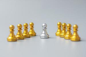 Goldene Schachfiguren oder Führergeschäftsmann heben sich von der Menge der silbernen Männer ab. Führungs-, Geschäfts-, Team-, Teamarbeits- und Personalmanagementkonzept foto