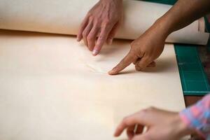 Nahansicht und Ernte Hände von Leder Handwerker zeigen beim das Fehler von das Weiß Leder foto