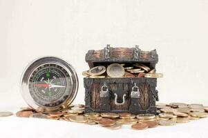ein hölzern Truhe mit Münzen und ein Kompass foto