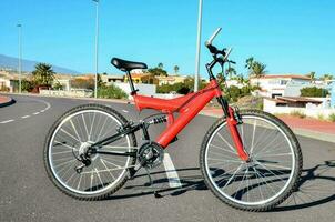 ein rot Fahrrad geparkt im das Mitte von das Straße foto