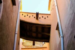 ein eng Gasse mit ein hölzern Strahl und ein Fenster foto