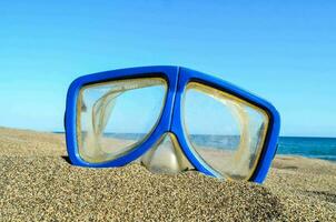 ein Blau und Gelb Tauchen Maske auf das Strand foto