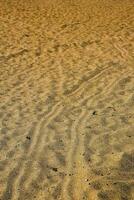 ein Sand Strand mit Wellen und Wellen im das Sand foto