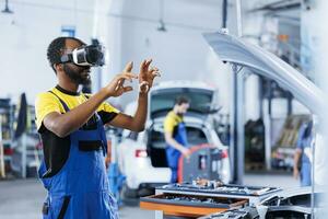 Experte im Auto Reparatur Geschäft mit virtuell Wirklichkeit zu visualisieren Auto Zündung System im bestellen zu Fix Es. bipoc erfahren Garage Arbeiter tragen futuristisch vr Headset während Arbeiten auf fehlerhaft Fahrzeug foto